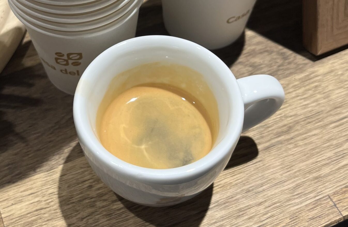 Espresso s defektnou crémou. Créma je veľmi tenká, rýchlo sa roztrhla a nezachovala si súdržnosť. To naznačuje, že espresso bolo podextrahované – pravdepodobne kvôli príliš hrubému mletiu, nízkemu dávkovaniu kávy alebo krátkemu času extrakcie. Výsledkom je svetlá, nestabilná créma a nevýrazná chuť s kyslými tónmi.